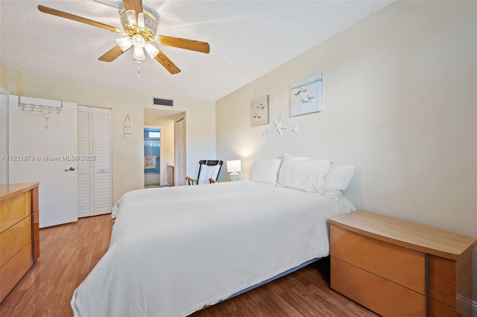3140 Holiday Springs Boulevard, Unit 9102 Margate, FL 33063 - Photo 24 of 35 a spacious bedroom with a bed and a chandelier