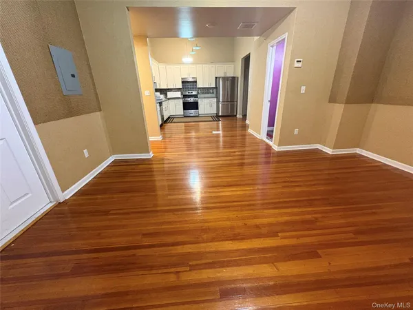 a view of a kitchen with kitchen island a sink wooden floor and living room