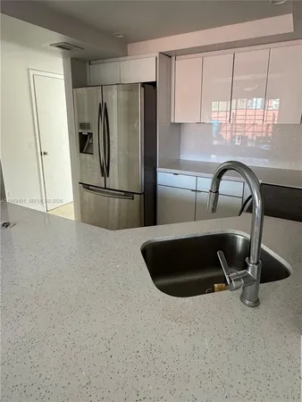 a kitchen with a refrigerator a sink a stove and a window