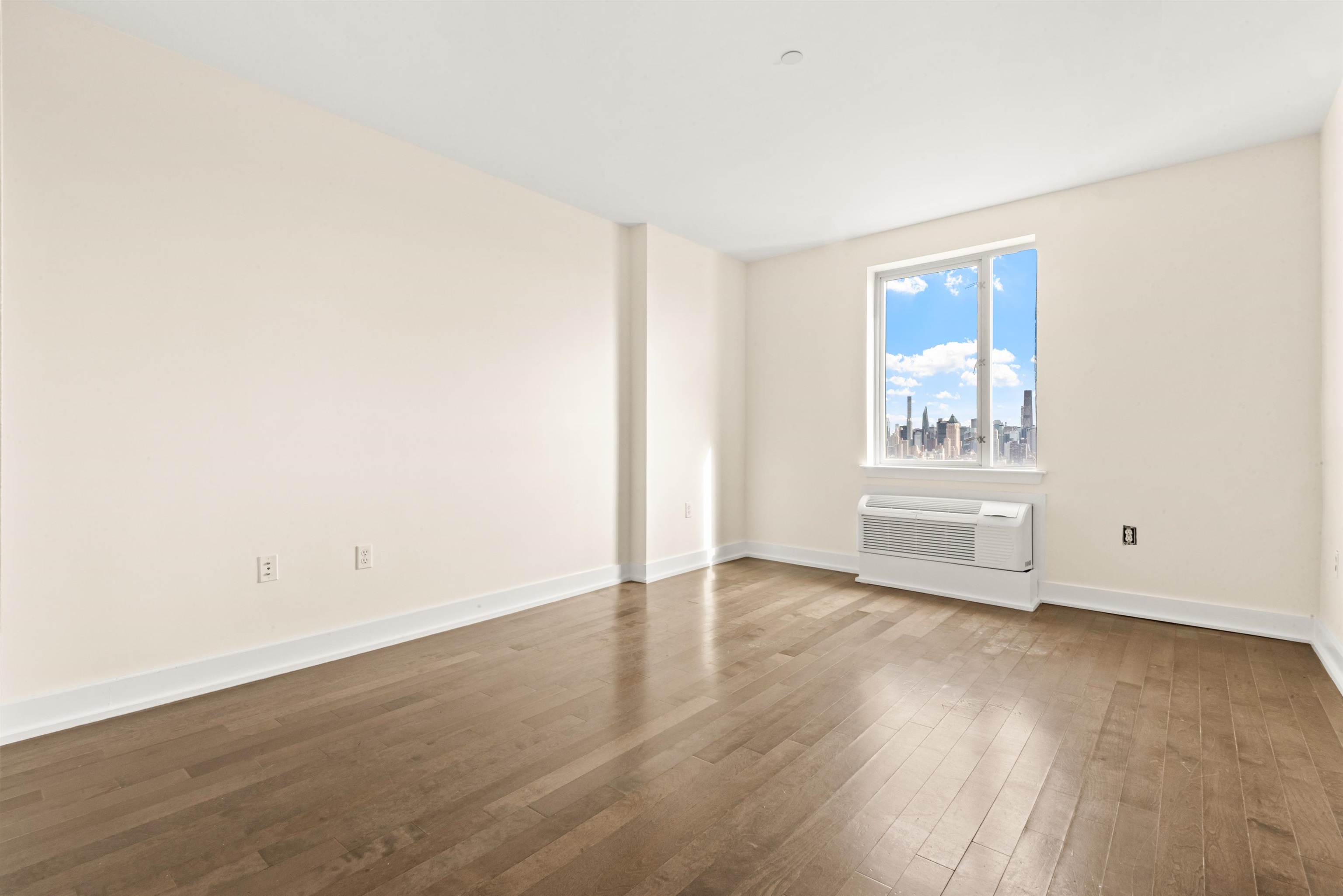 3312 Hudson Avenue, Unit 12F Union City, NJ 07087 - Photo 17 of 32 an empty room with wooden floor and windows