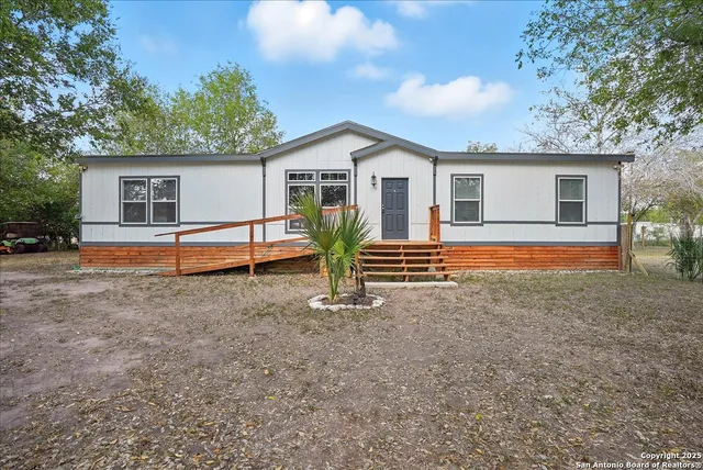 a view of a house with backyard and trees