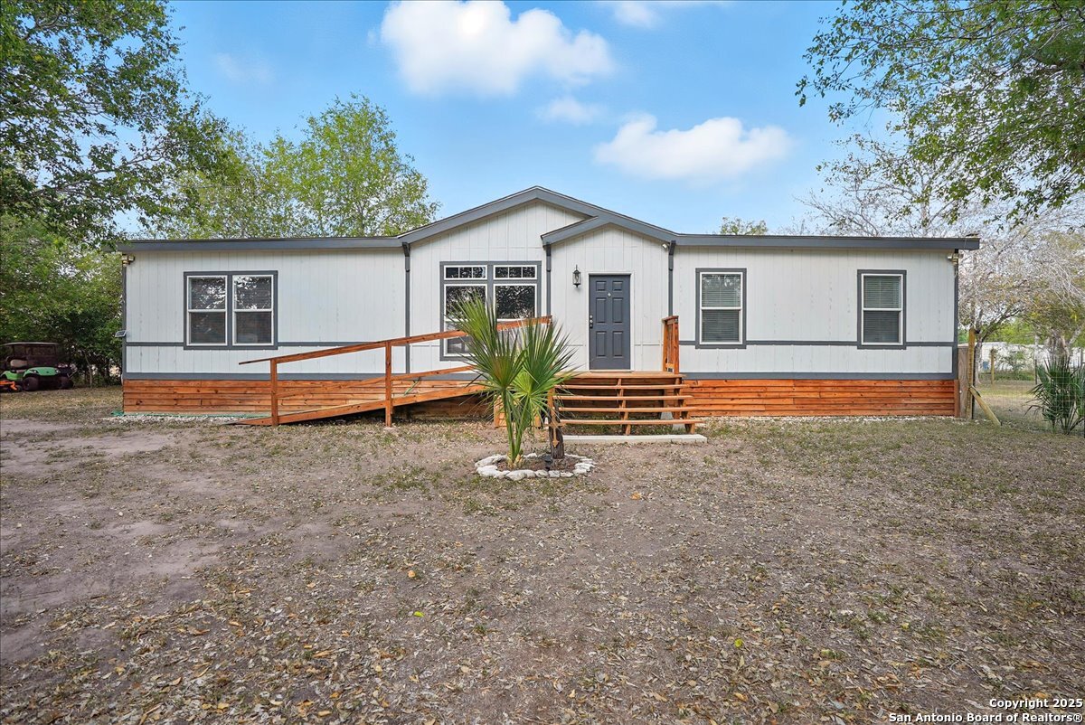 a view of a house with backyard and trees