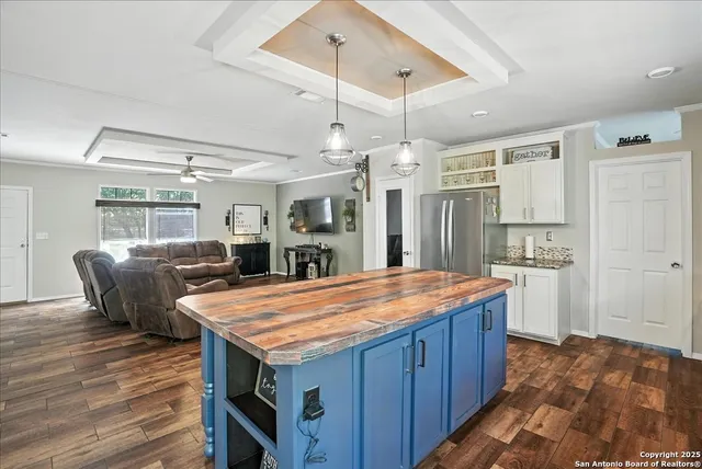 a dining hall with stainless steel appliances granite countertop a kitchen island a stove and a refrigerator