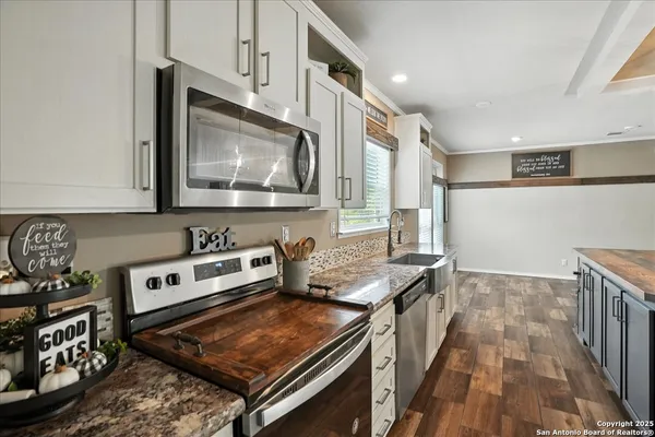 a kitchen with stainless steel appliances granite countertop a stove and a microwave