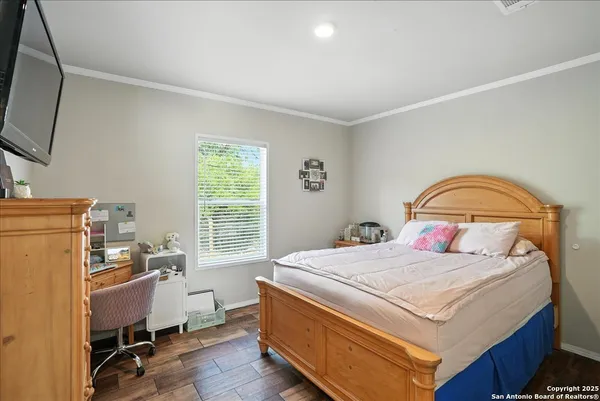 a bedroom with a bed and a flat tv screen on the dresser