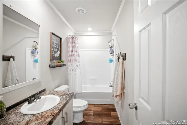 a bathroom with a sink toilet a mirror and shower