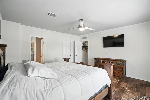 a bedroom with a bed and a flat tv screen on wall