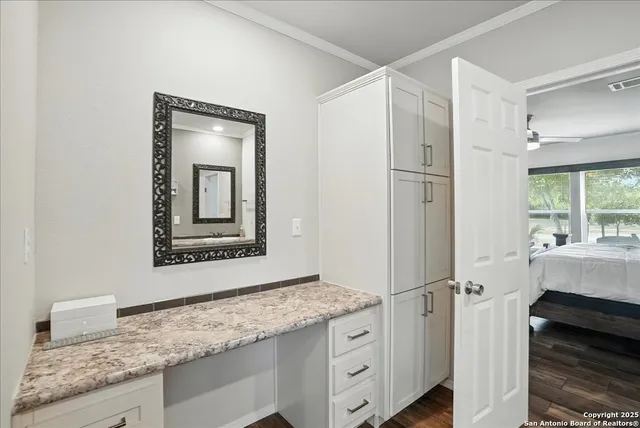 a bathroom with a granite countertop sink mirror and cabinets