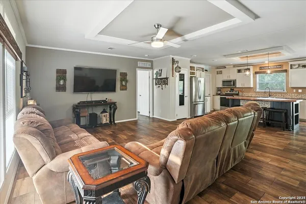 a living room with furniture a flat screen tv and a large window