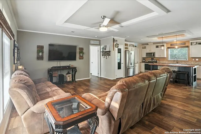 a living room with furniture a flat screen tv and a large window