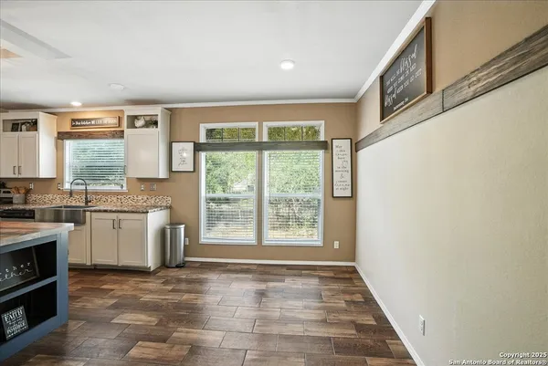 a view of a kitchen with a sink and dishwasher with wooden floor