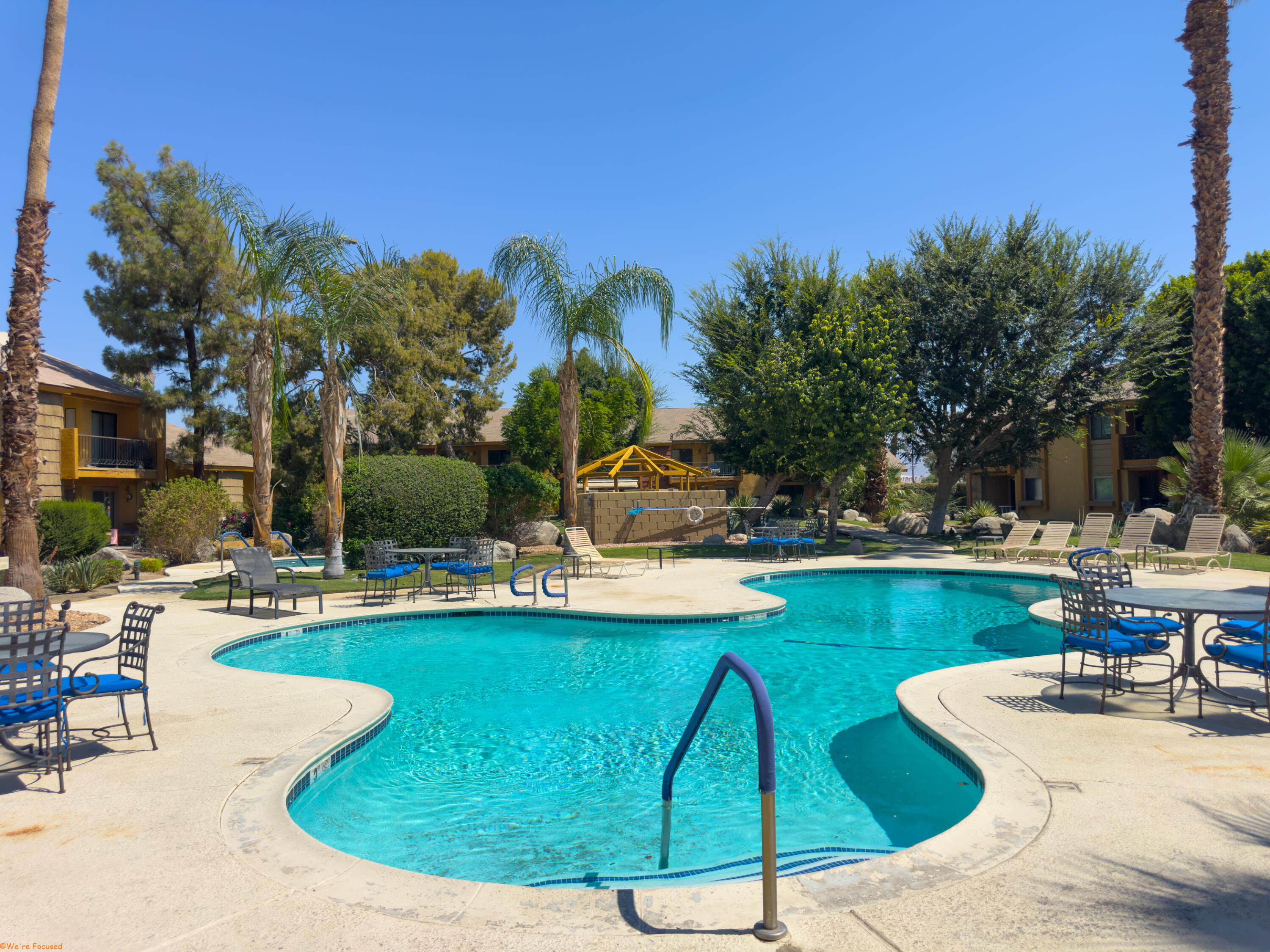 48255 Monroe Street, Unit 2 Indio, CA 92201 - Photo 26 of 35 a view of a swimming pool with a table and chairs