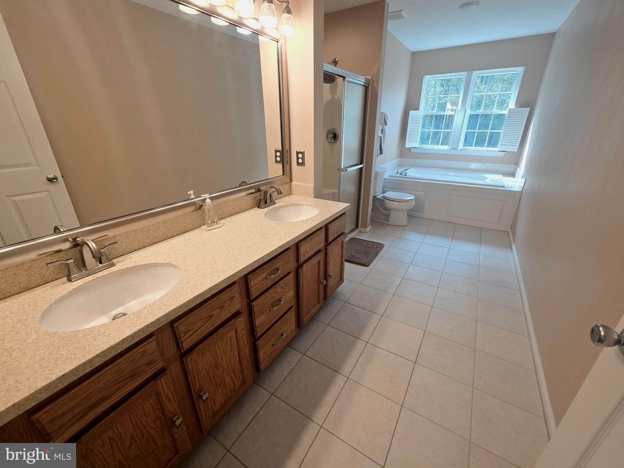 644 Surrey Road Sewell, NJ 08080 - Photo 28 of 37 a spacious bathroom with a double vanity sink a mirror and a bathtub