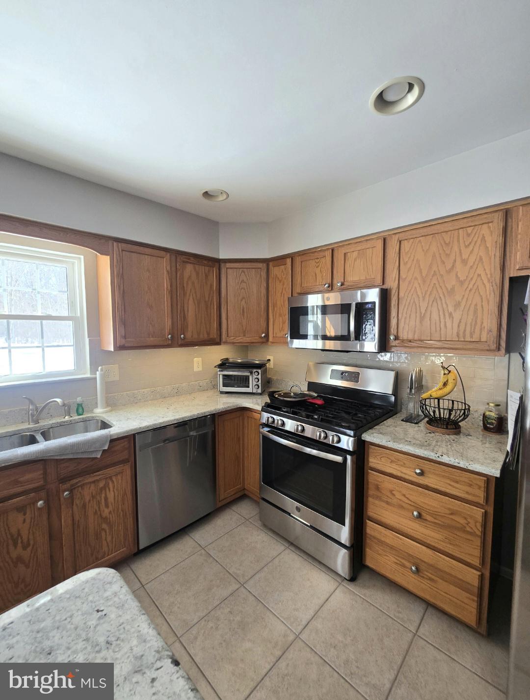644 Surrey Road Sewell, NJ 08080 - Photo 4 of 37 a kitchen with stainless steel appliances granite countertop a stove a sink and a microwave