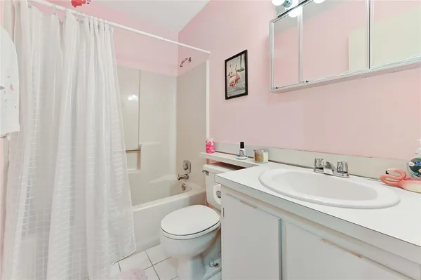 a bathroom with a sink a toilet and shower curtain