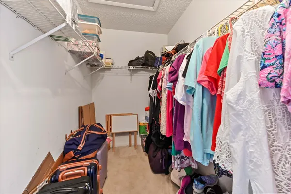 a view of walk in closet with clothes and shoes