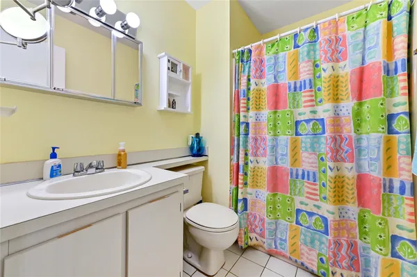 a bathroom with a sink toilet and shower curtain