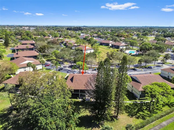 an aerial view of residential houses with outdoor space and trees
