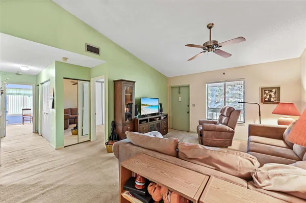 a living room with furniture a ceiling fan and a wooden floor