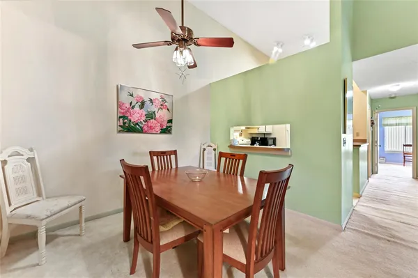 a view of a dining room with furniture and a chandelier fan