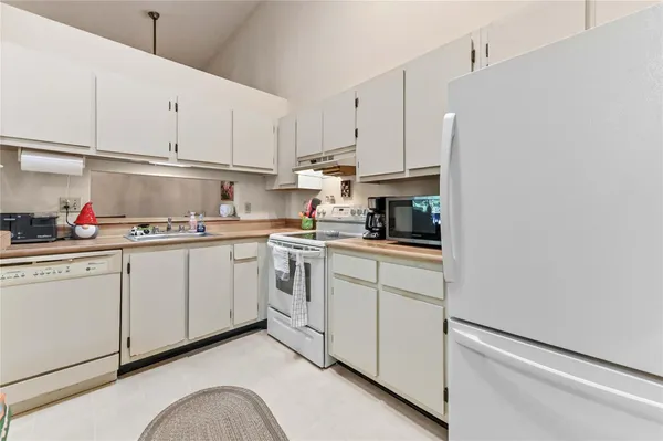 a kitchen with white cabinets and white appliances