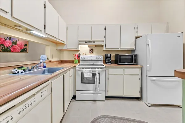 a kitchen with white cabinets and white appliances