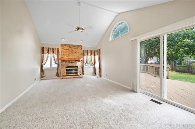 en empty room with windows and fireplace