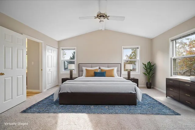 a spacious bedroom with a bed a chandelier and a window