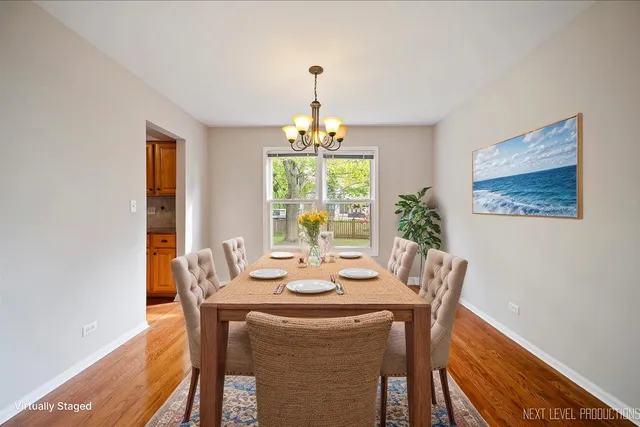 a dining room with furniture a chandelier and wooden floor