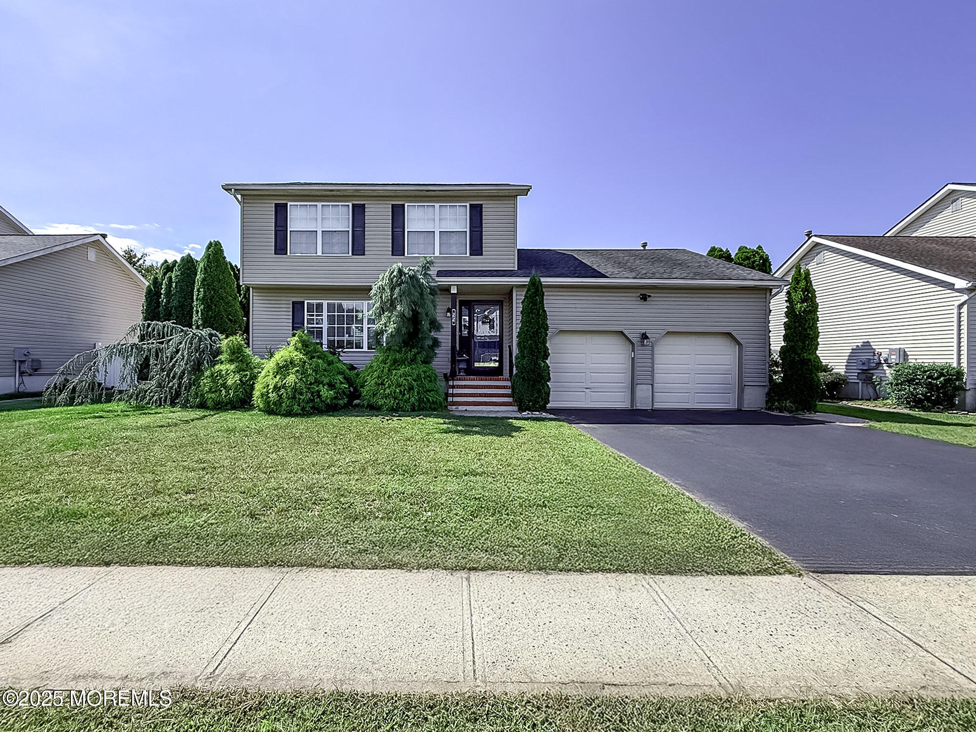 a front view of a house with a garden and yard