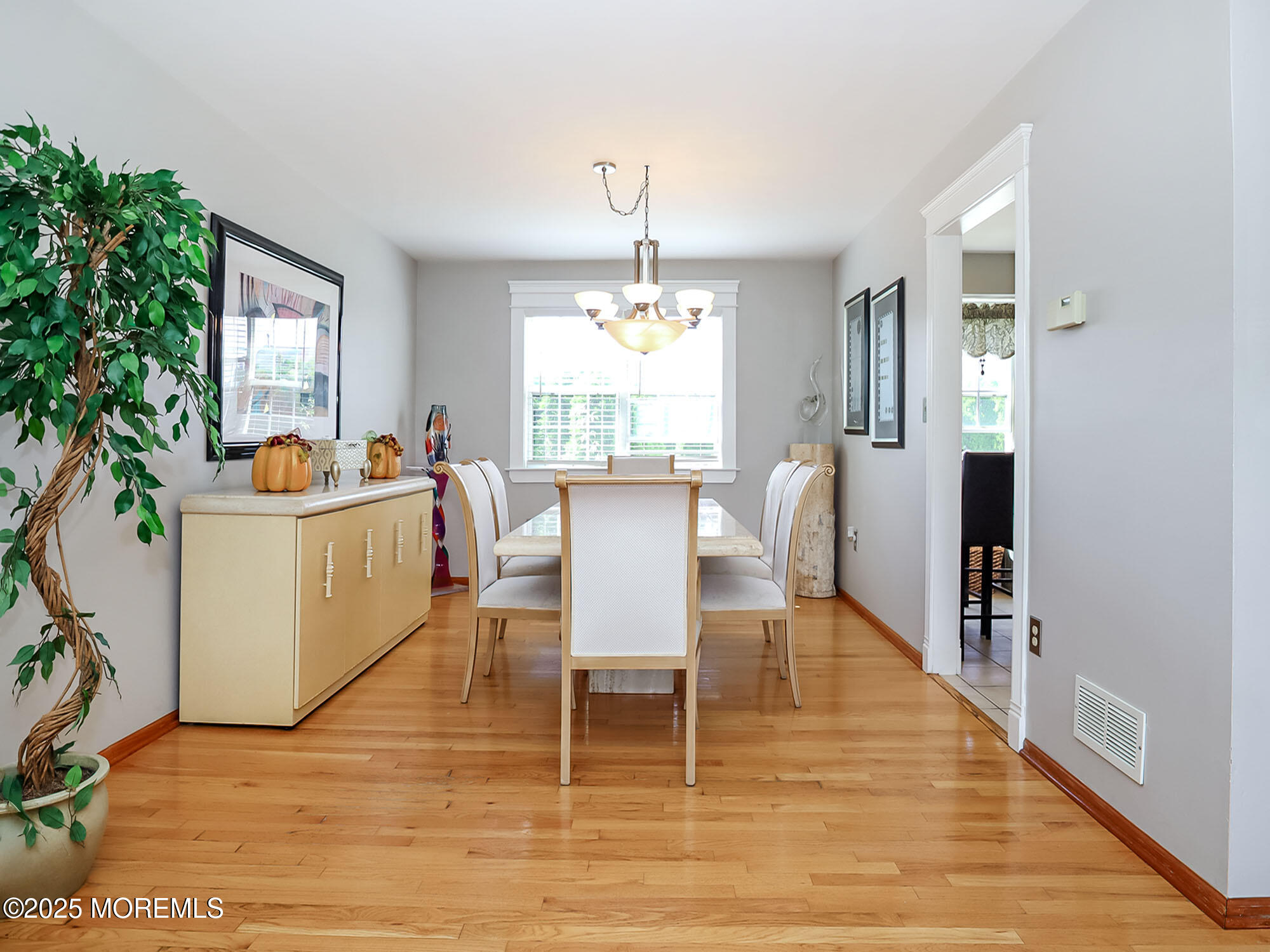 22 Abraham Drive Howell, NJ 07731 - Photo 9 of 24 a dining room with wooden floor a chandelier a glass table and chairs
