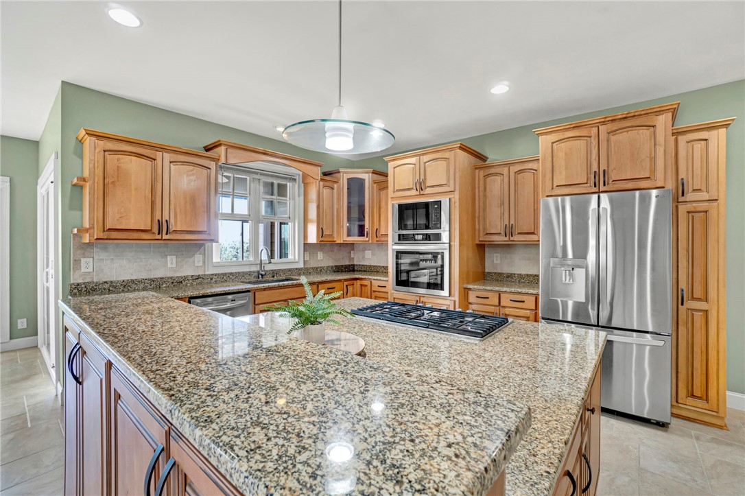 603 Tamassee Ridge Way Salem, SC 29676 - Photo 18 of 46 This spacious kitchen offers ample granite counter space, natural wood cabinetry, and modern appliances.