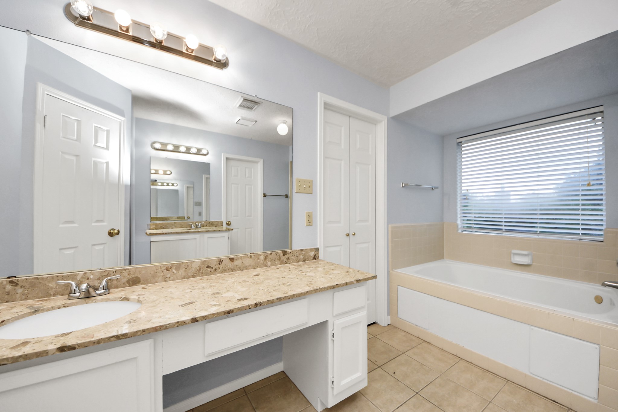 2102 Gemini Avenue Houston, TX 77058 - Photo 29 of 40 a bathroom with a granite countertop tub sink and mirror