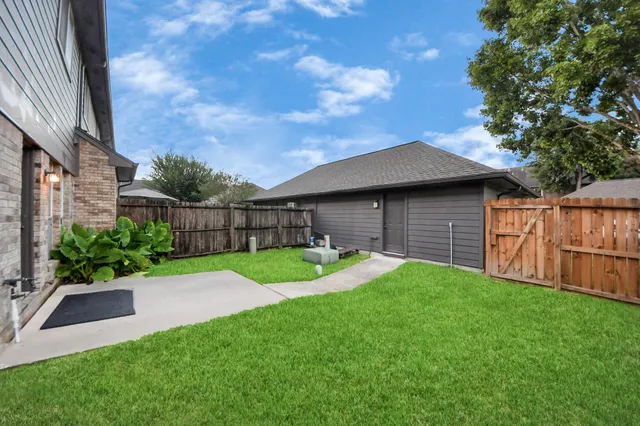 a view of backyard with table and chairs and wooden fence