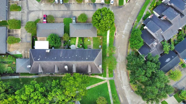 an aerial view of a house and a yard and tennis court