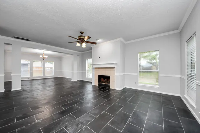 an empty room with windows and fireplace