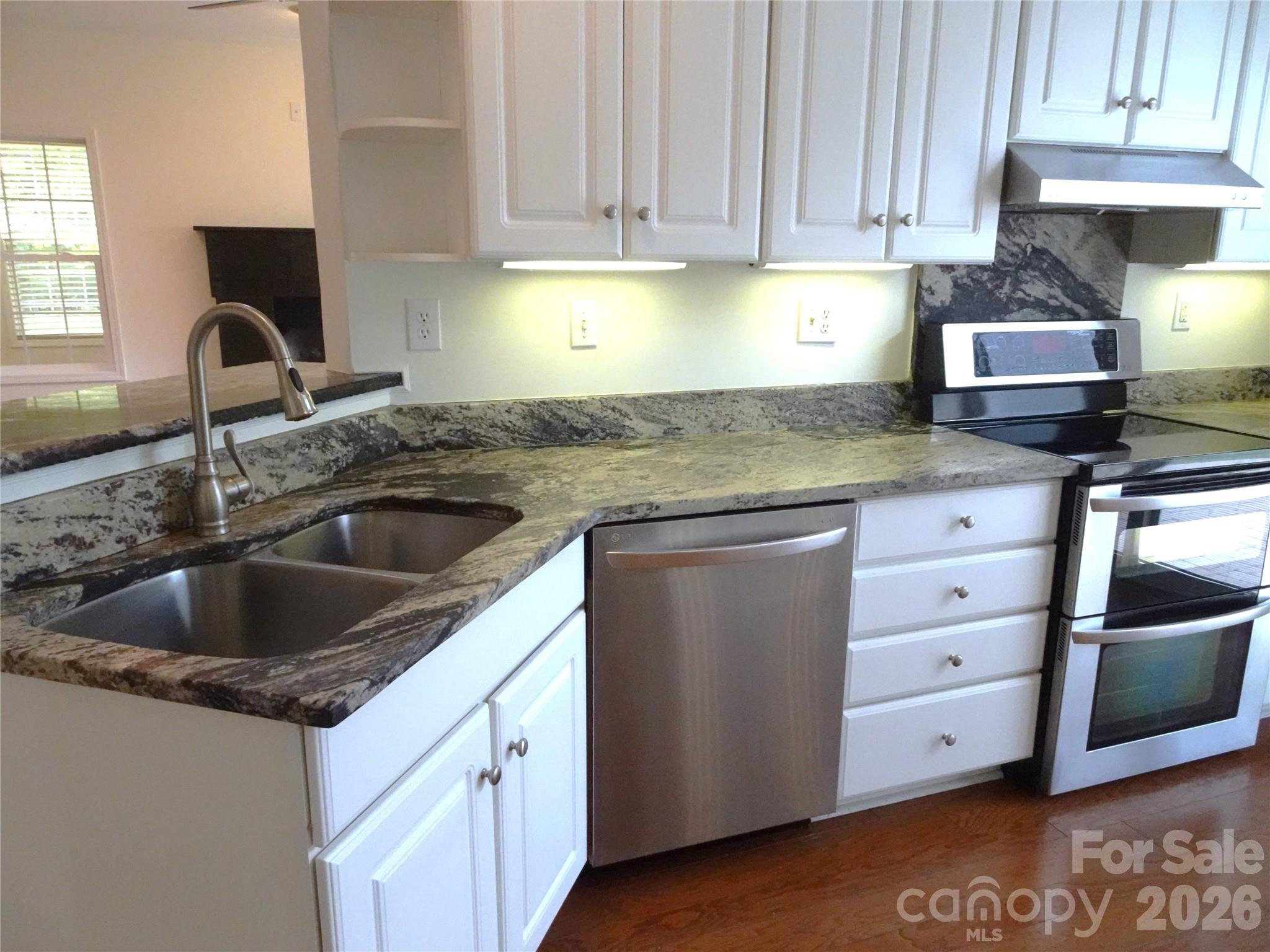 35 Sheffield Place Brevard, NC 28712 - Photo 16 of 38 a kitchen with granite countertop a sink dishwasher and cabinets with wooden floor
