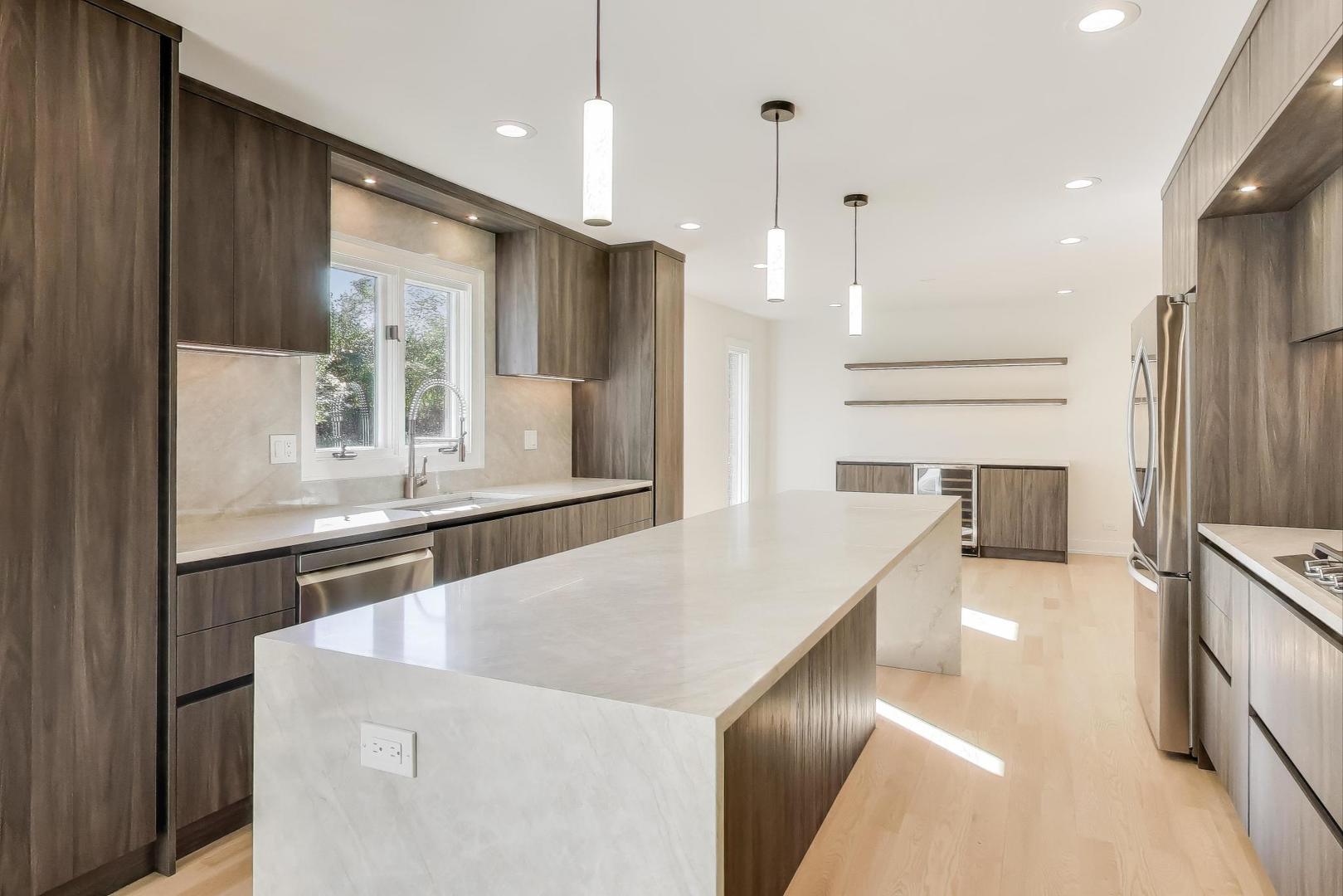 73 Augusta Drive Deerfield, IL 60015 - Photo 6 of 39 a kitchen with stainless steel appliances kitchen island granite countertop a refrigerator a oven and a sink with large window