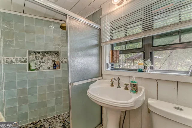 a view of a house with a yard and table and chairs under an umbrella