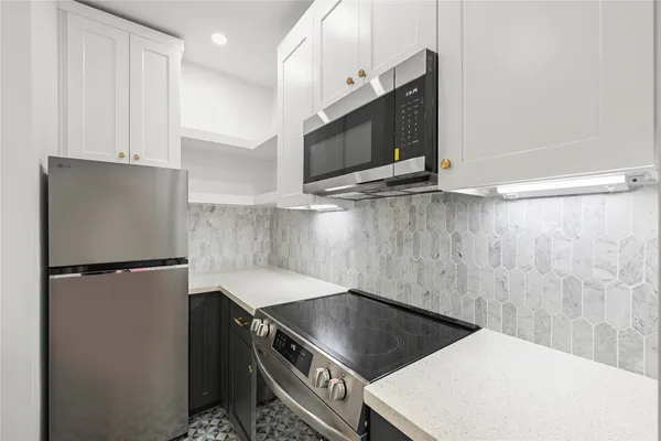 a kitchen with a refrigerator and a stove top oven