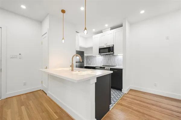 a kitchen with kitchen island a sink stainless steel appliances and cabinets