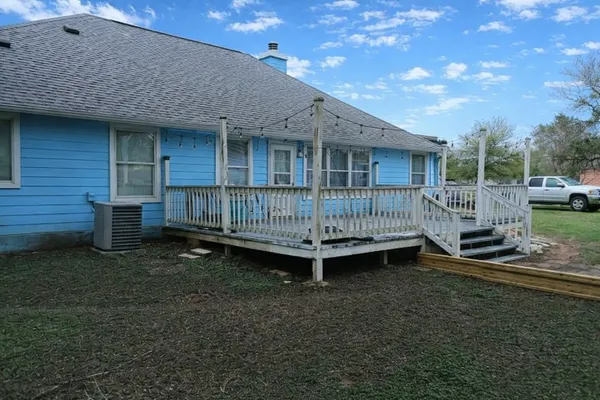 a view of a chair and table in backyard of the house