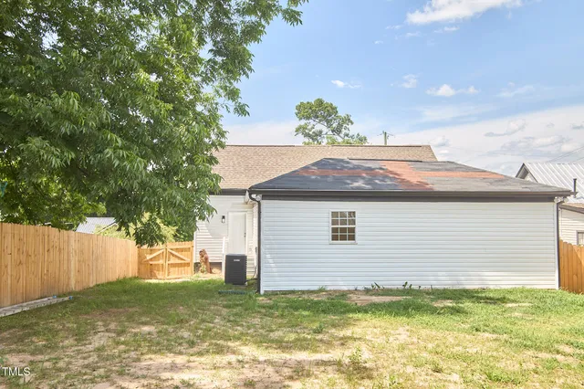 a view of a hallway with wooden floor and a living room
