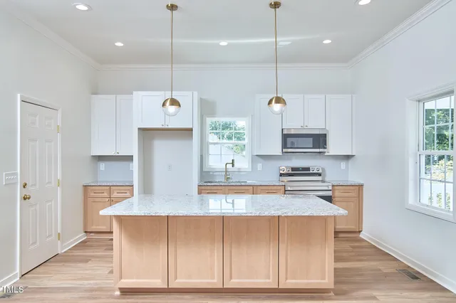 a kitchen with stainless steel appliances granite countertop a sink a stove and a wooden floors