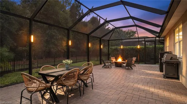 a view of a outdoor space with table and chairs under an umbrella