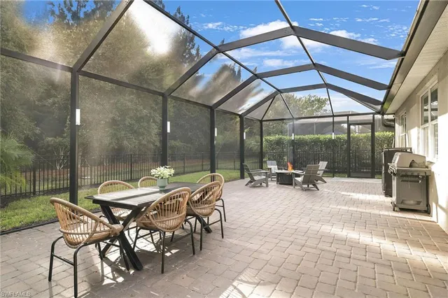 a view of a patio with a table and chairs and a barbeque