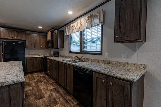 a kitchen with stainless steel appliances granite countertop a sink stove and cabinets