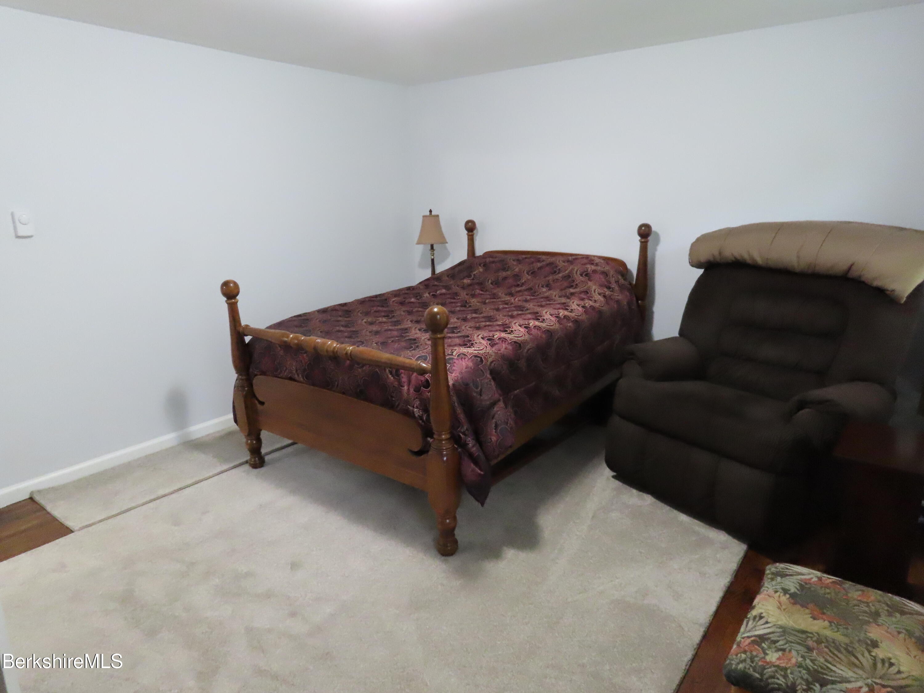 1580 Main Road Stamford, VT 05352 - Photo 19 of 39 a spacious bedroom with a bed and a couch