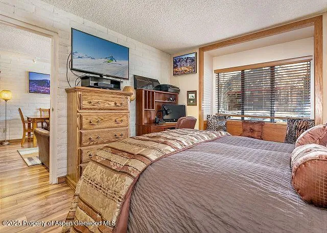 a bedroom with a bed a couch and large window