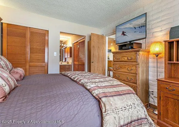 a bedroom with a bed and dresser with mirror